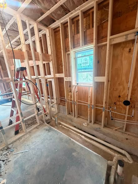 New supply and drain lines roughed in on a framed bathroom wall